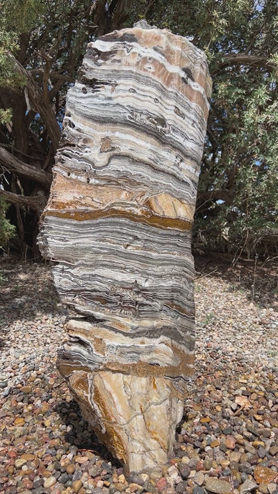 Vertical banded Black Canyon Onyx stone fountain by The Rock Star Gallery in courtyard patio landscape design.