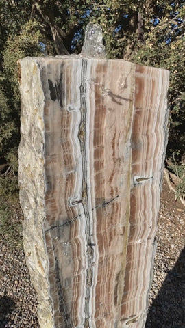 Vertical banded Black Canyon Onyx stone fountain by The Rock Star Gallery in courtyard patio landscape design.