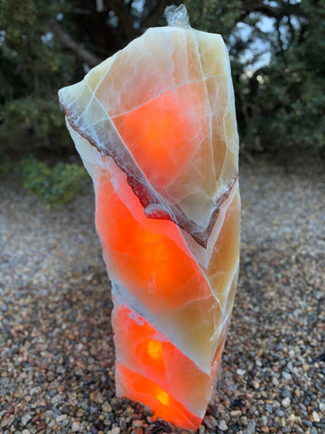 Glowing Sunrise Onyx stone fountain by The Rock Star Gallery in a landscape setting.