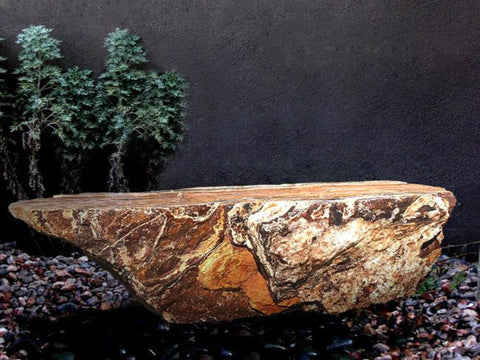 Black Canyon Onyx stone bench from The Rock Star Gallery in a garden courtyard landscape design.
