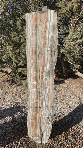 Vertical banded Black Canyon Onyx stone fountain by The Rock Star Gallery in courtyard patio landscape design.